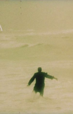 man walking into ocean