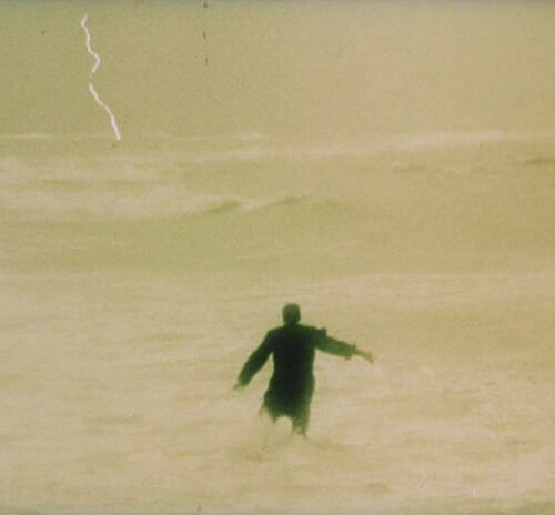 man walking into ocean